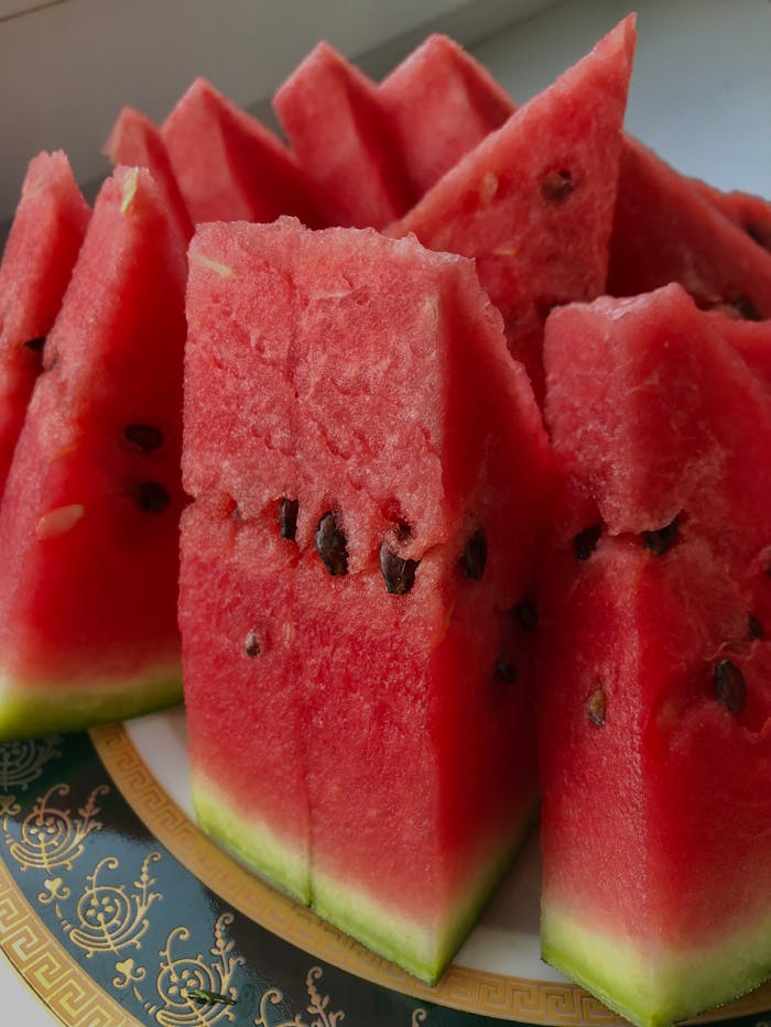 Close-up of juicy watermelon slices arranged on a decorative plate, showcasing freshness.