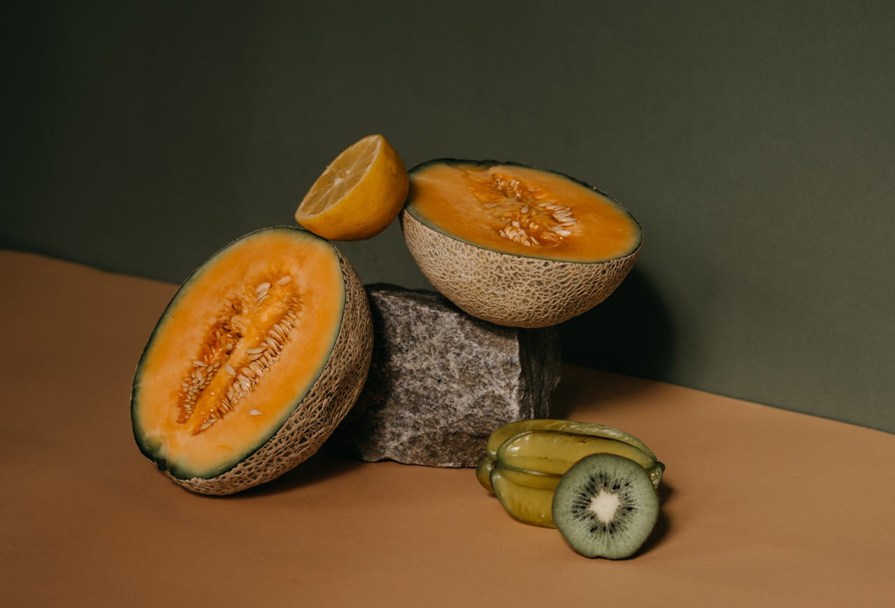 Elegantly arranged tropical fruits with a minimalist backdrop, showcasing the textures and colors of melon, kiwi, and carambola.